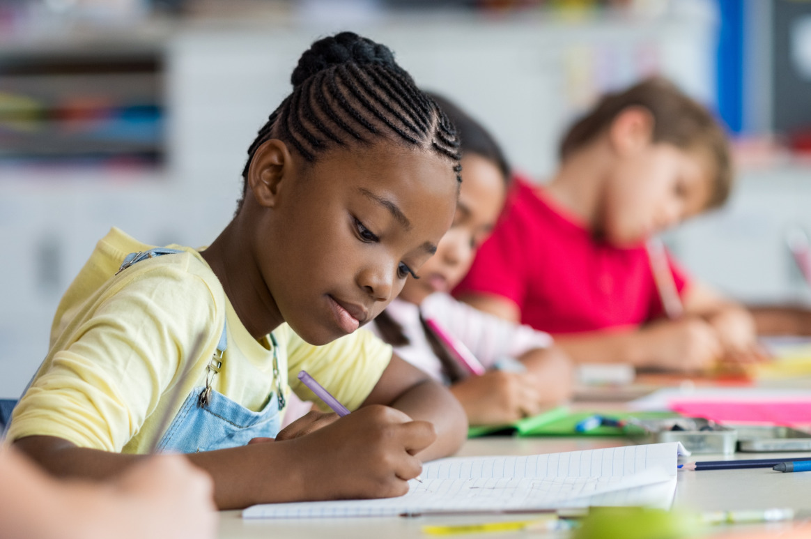 Focused young student participating in an ABA therapy school setting, developing academic and behavioral skills with structured support for individualized learning success.