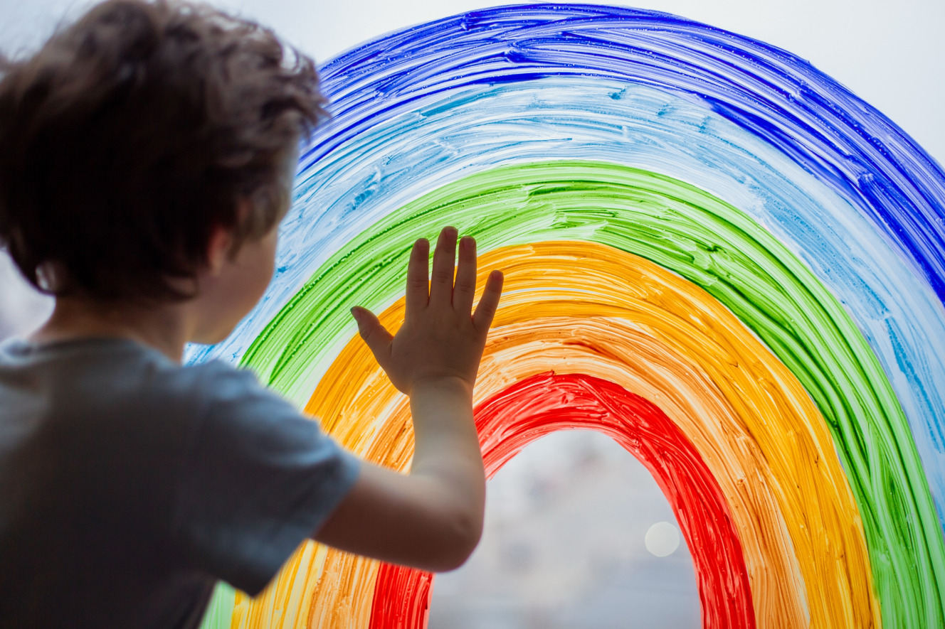 Child engaging in a sensory activity guided by an ABA therapy specialist, using finger painting to enhance creativity, communication, and fine motor skills.